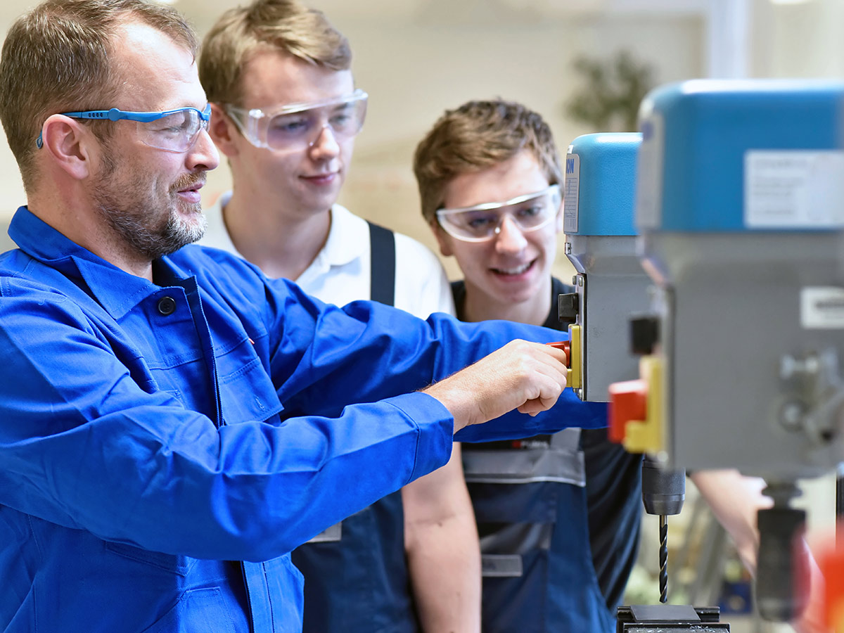 students working with a drill press